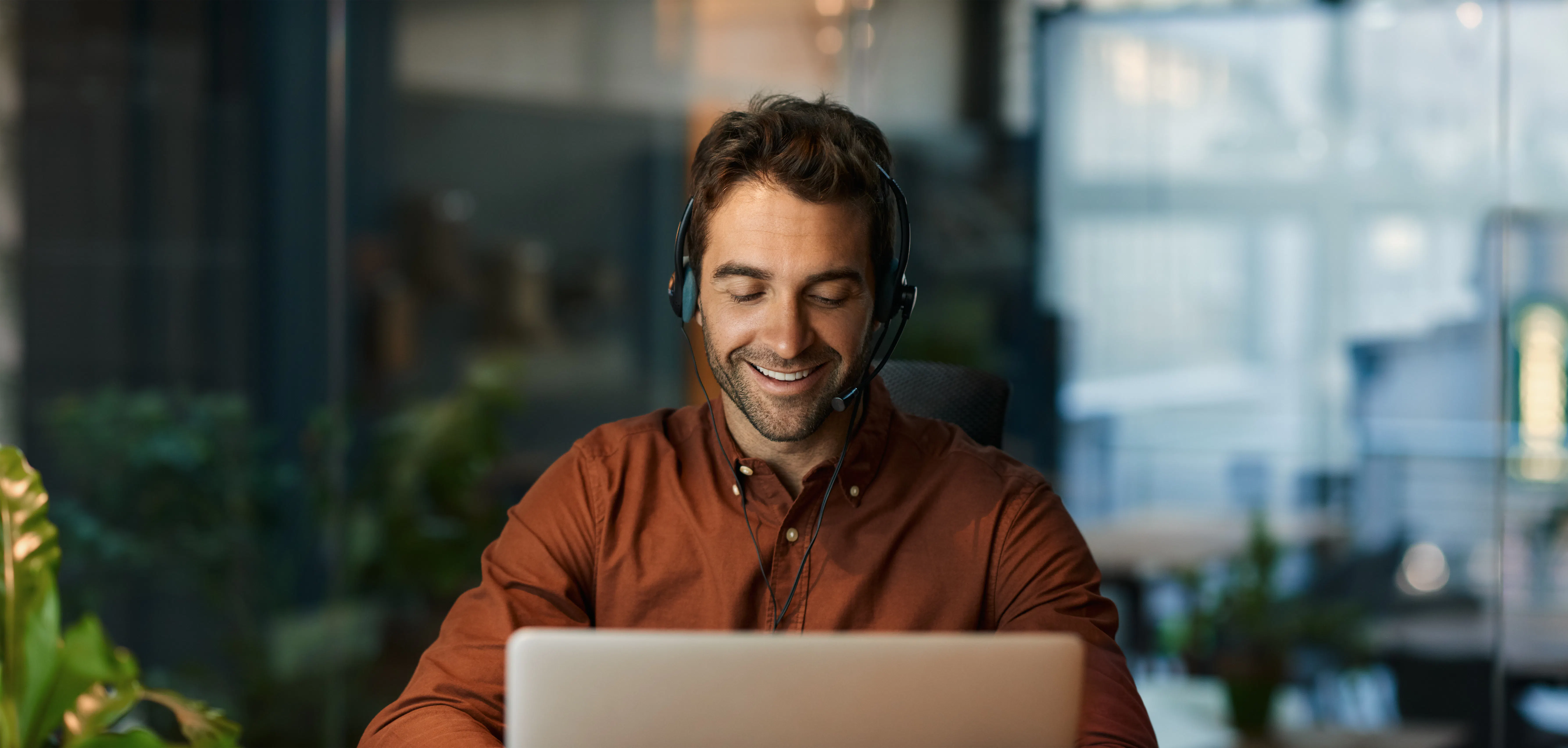 Man in Orange Working at Laptop