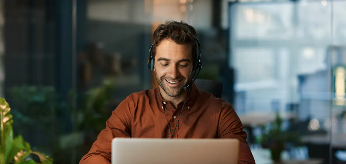 Man in Orange Working at Laptop