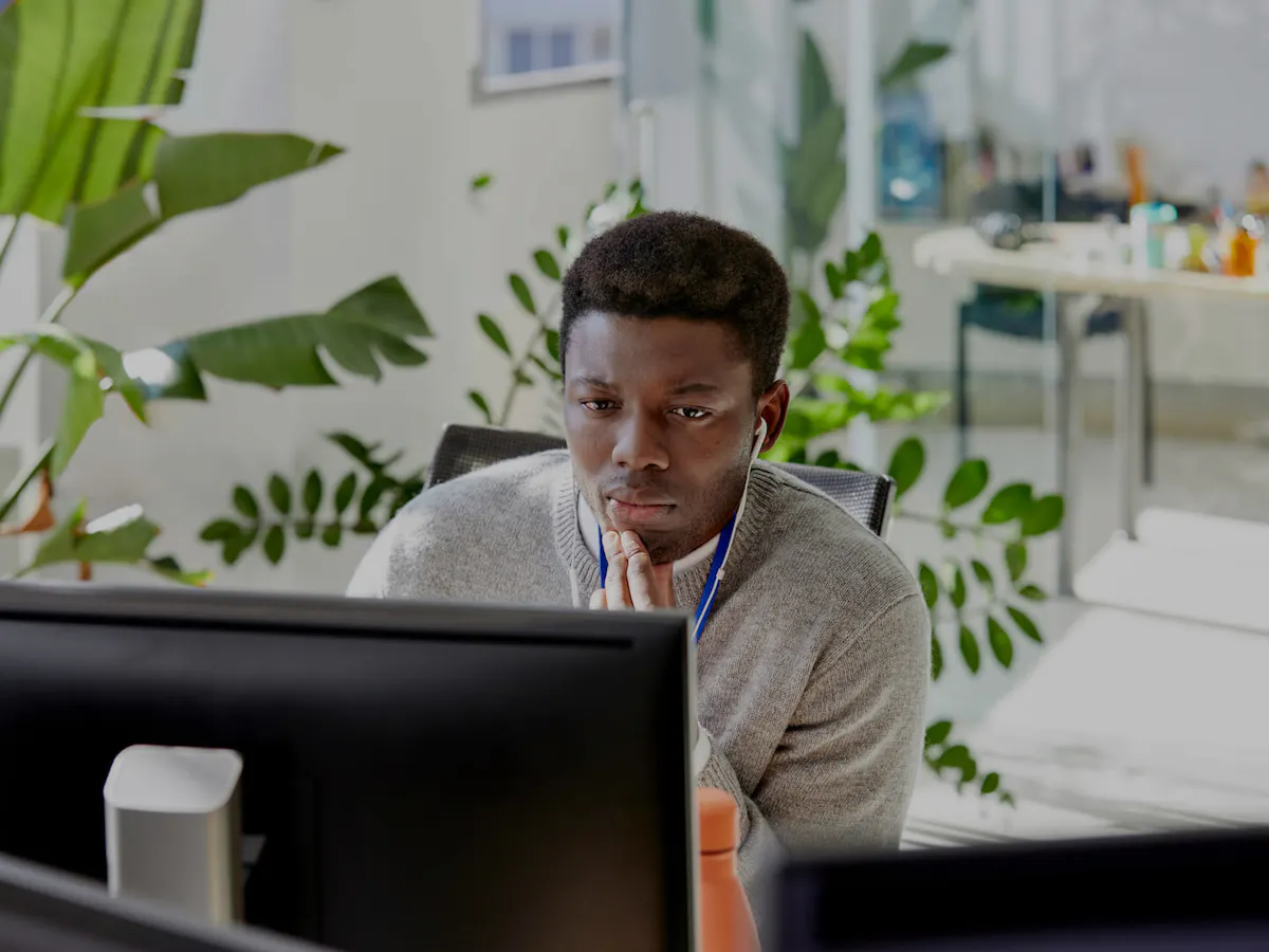 Man working at desktop with plants in the background