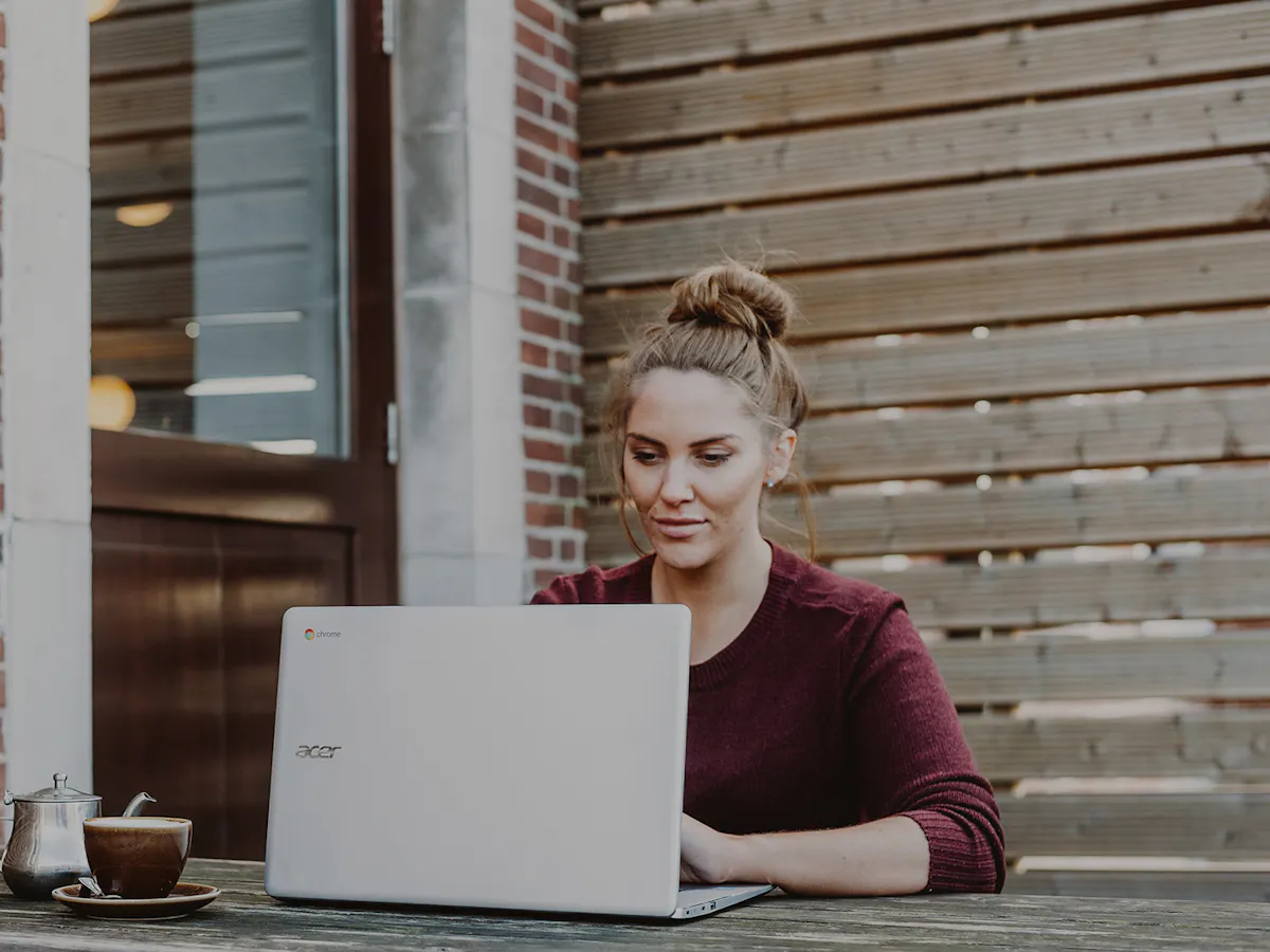 Woman on her laptop outside learning tech skills online