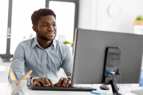 Man smiling at computer in office