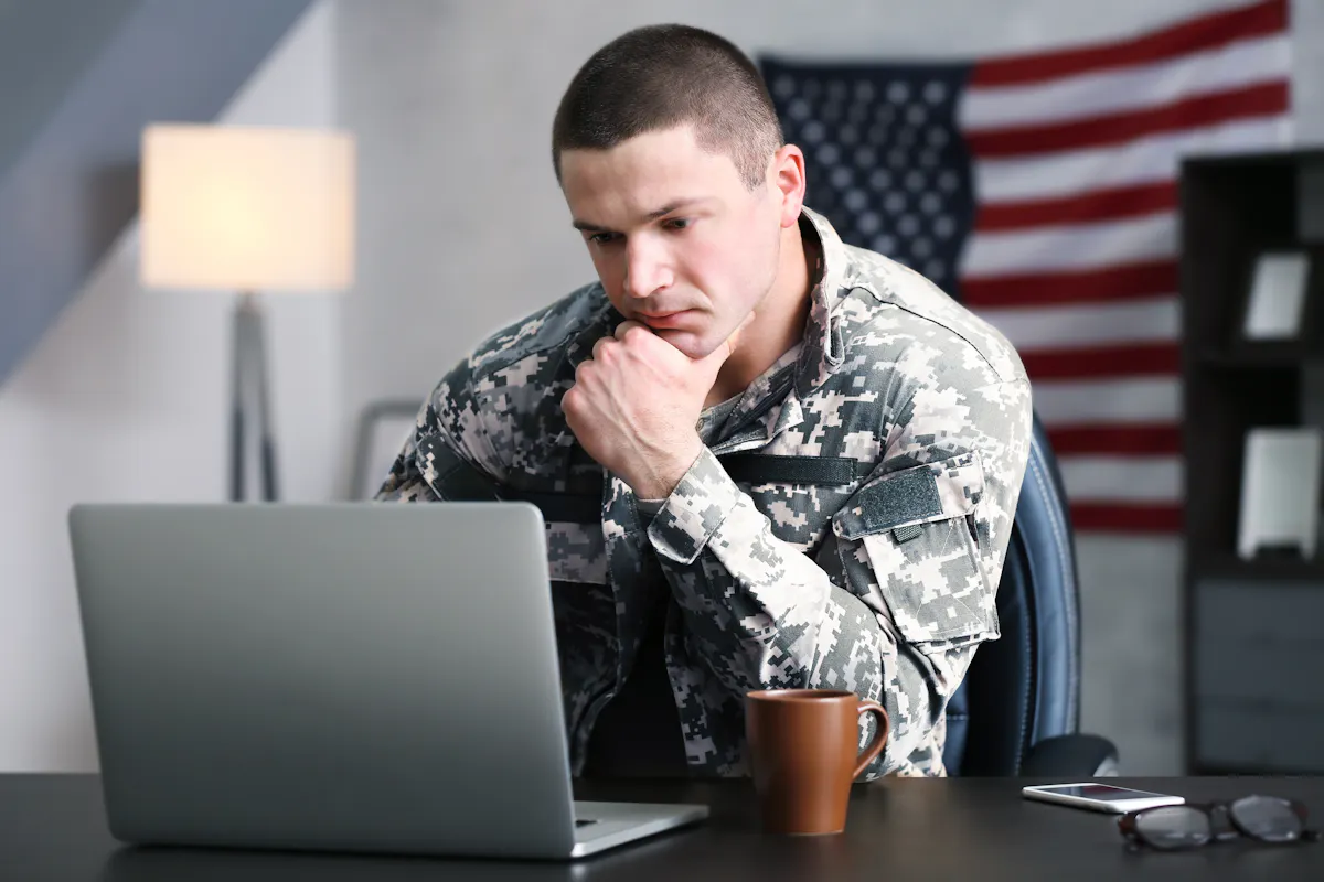 American soldier sitting at desk with computer