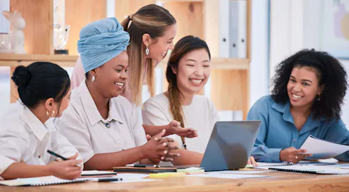 Group of diverse women working around a computer