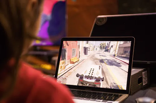 Professional video game programmer plays videos game on laptop