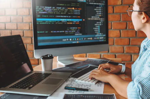 Woman coding in cafe brick wall