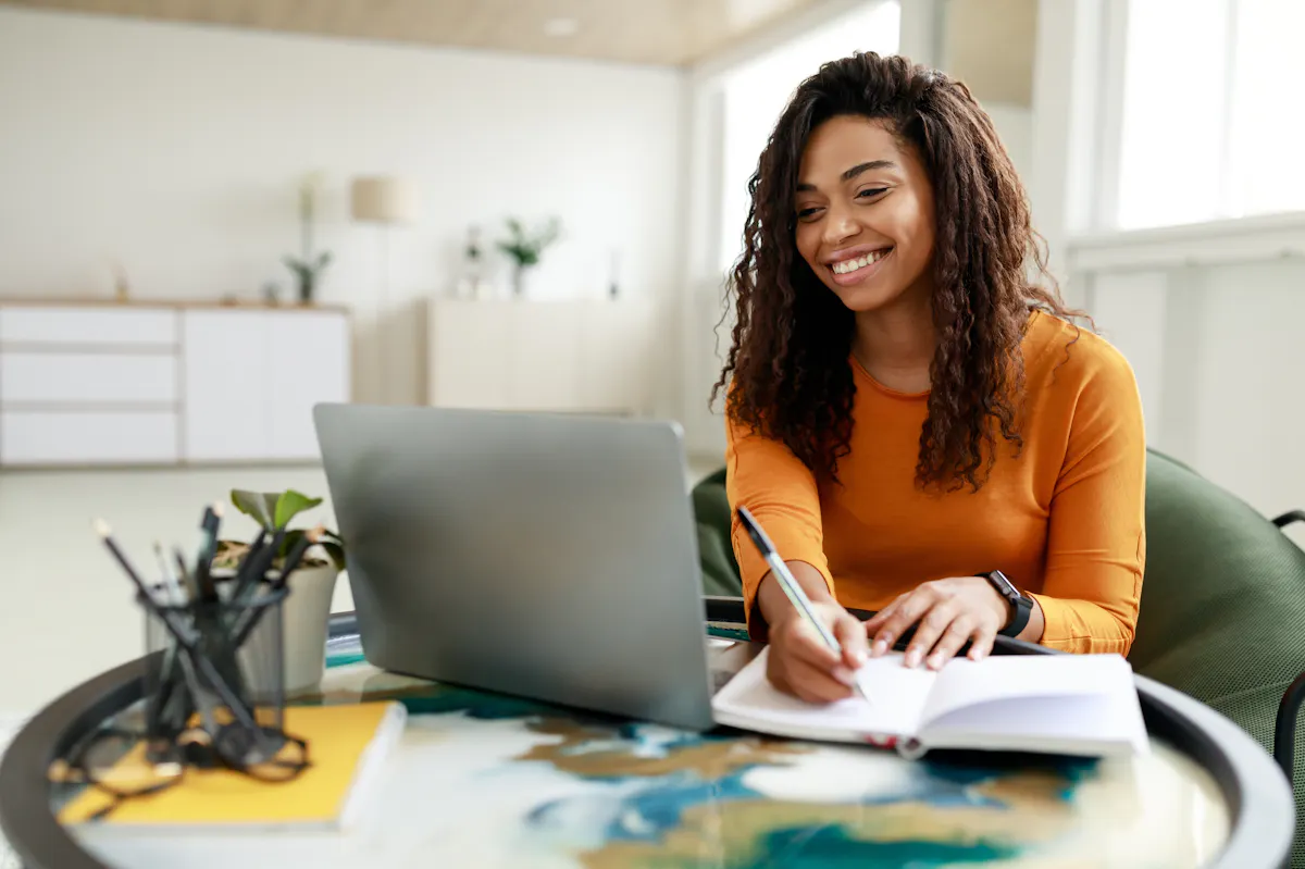 Woman in orange sweater working from home