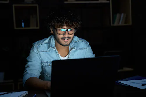 Young man studying cybersecurity late at night