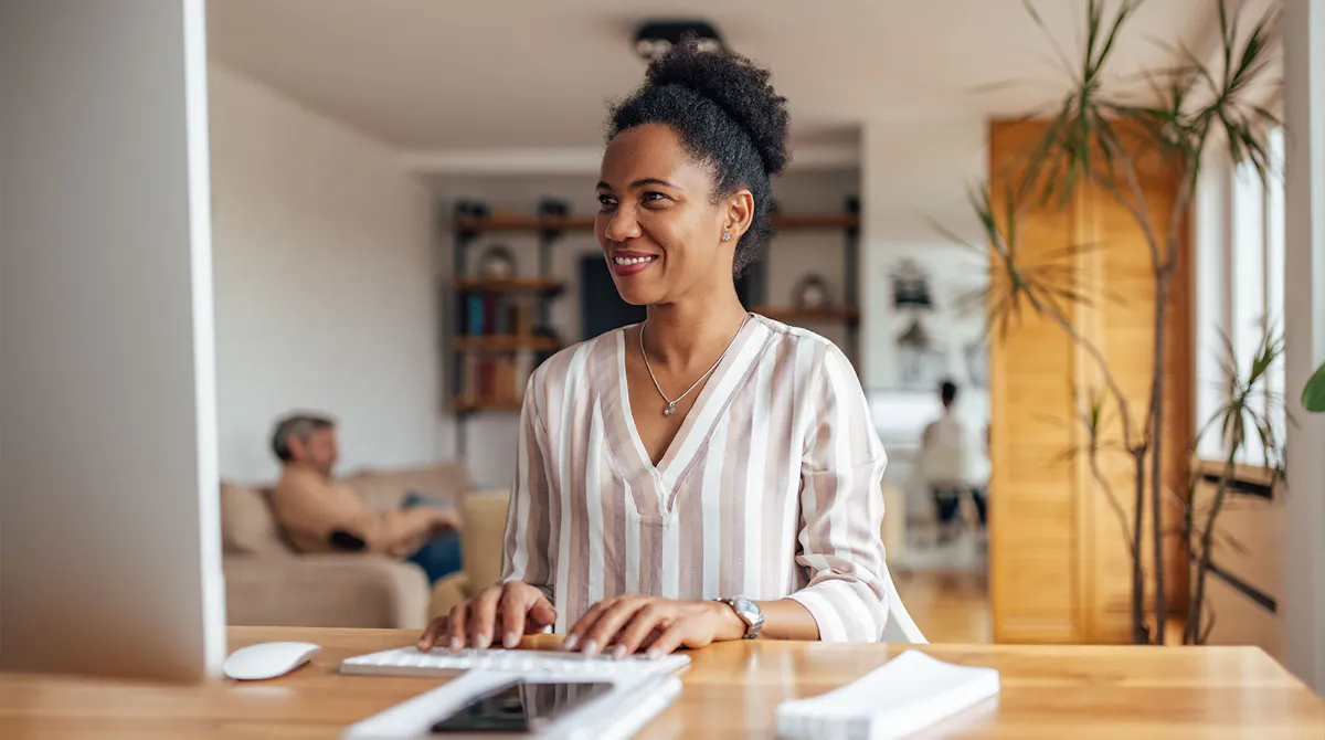Black woman smiling at laptop