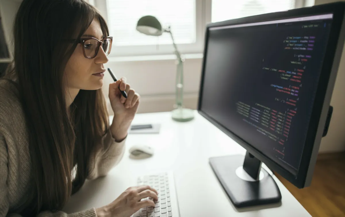 Woman in glasses looking at code