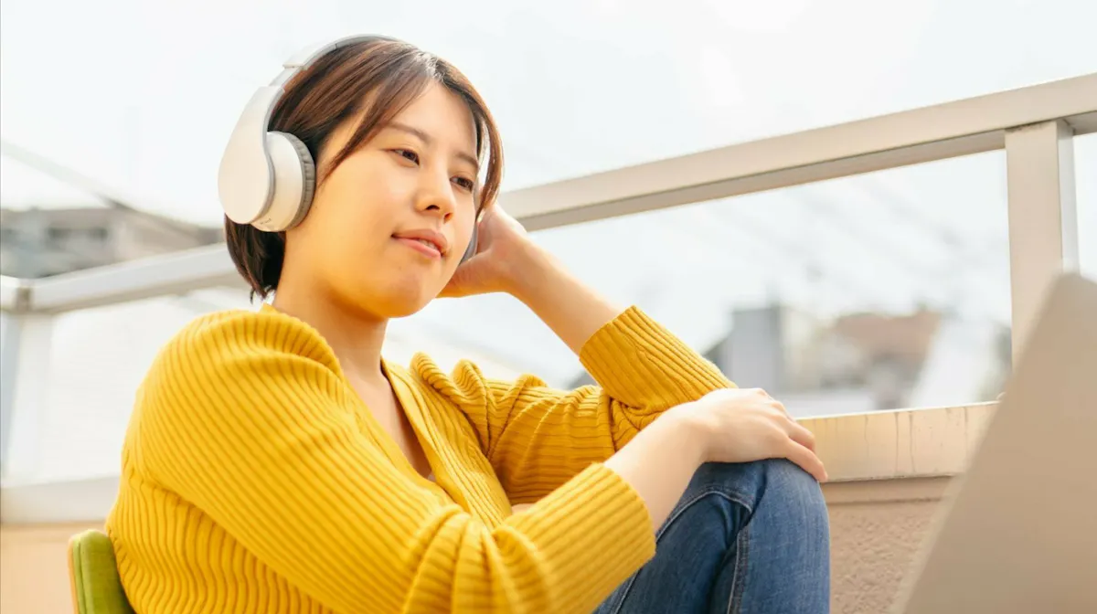 Asian woman yellow sweater learning outside