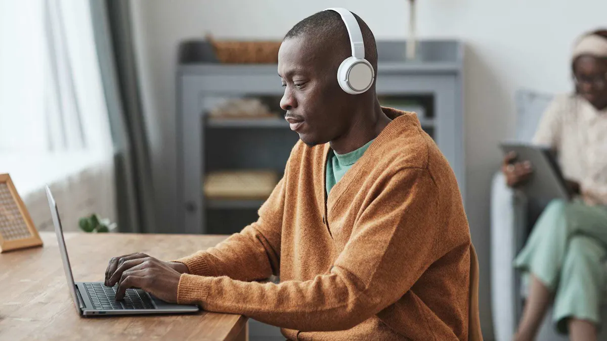 Man with headphones works on laptop