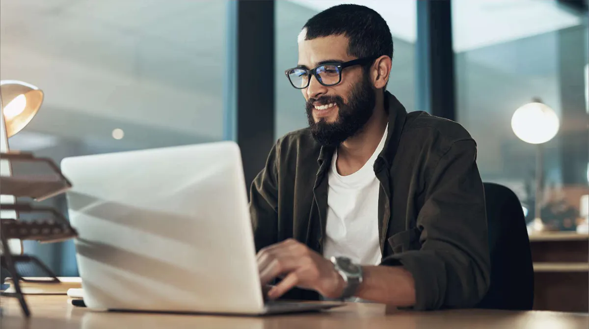 Man smiling at laptop flipped