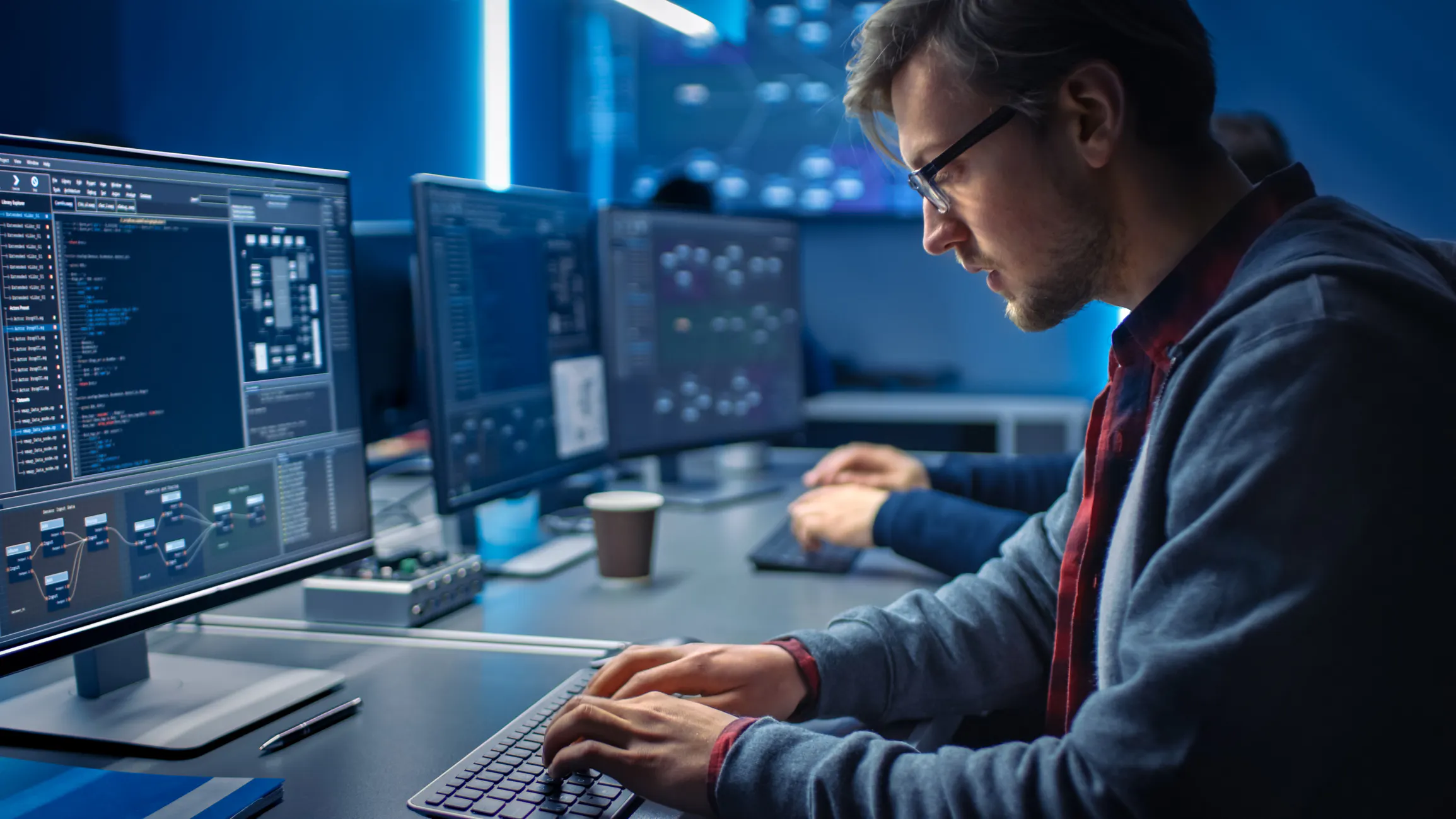 A cybersecurity professional in a data center works on a desktop computer.