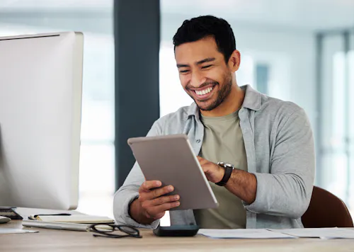 A product manager smiles while working on a tablet.