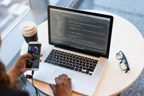 Laptop with code connected to smartphone a83bi