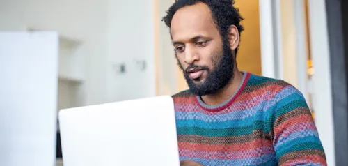 Man in sweater looking at screen