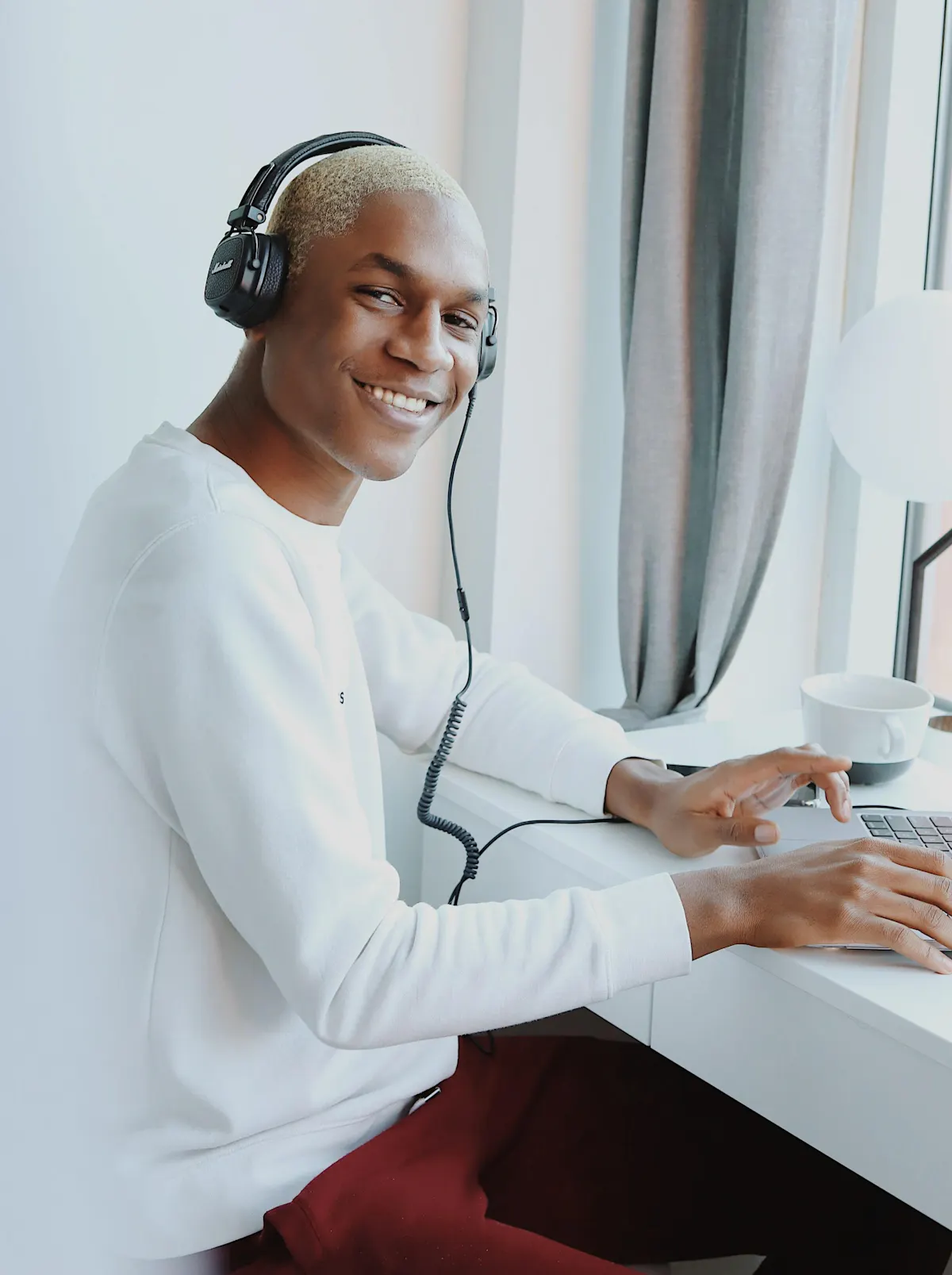 Man typing and smiling with headphones